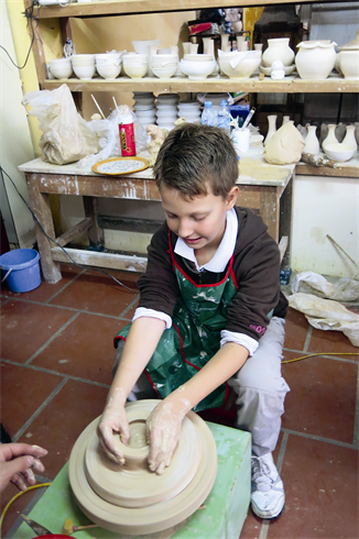 À Bat Tràng, un enfant confectionne lui-même un produit en céramique.