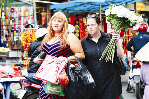 Des étrangers choisissent leurs espèces favorites au marché aux fleurs du Têt.