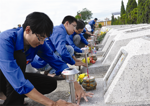 De jeunes volontaires participent à l’entretien d’un cimetière de soldats morts pour la Patrie.Lê Lâm/VNA/CVN    