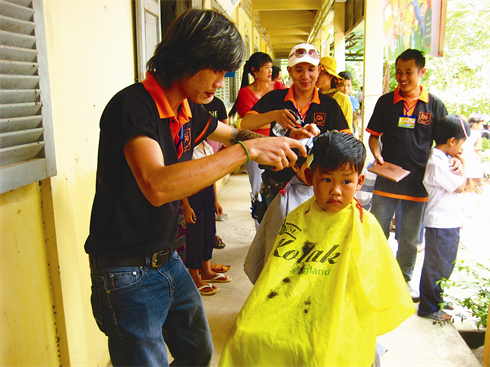 Les membres du groupe coupent les cheveux des enfants.