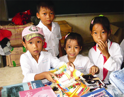 Les enfants sont heureux de recevoir des livres, cadeaux du 1er juin.