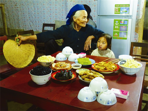Une vieille dame Nùng et son arrière-petite-fille avant un repas traditionnel de fête.