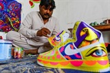 L’artiste Haider Ali peint une paire de baskets dans son studio de Karachi, le 28 février 2022. Photo : AFP/VNA/CVN